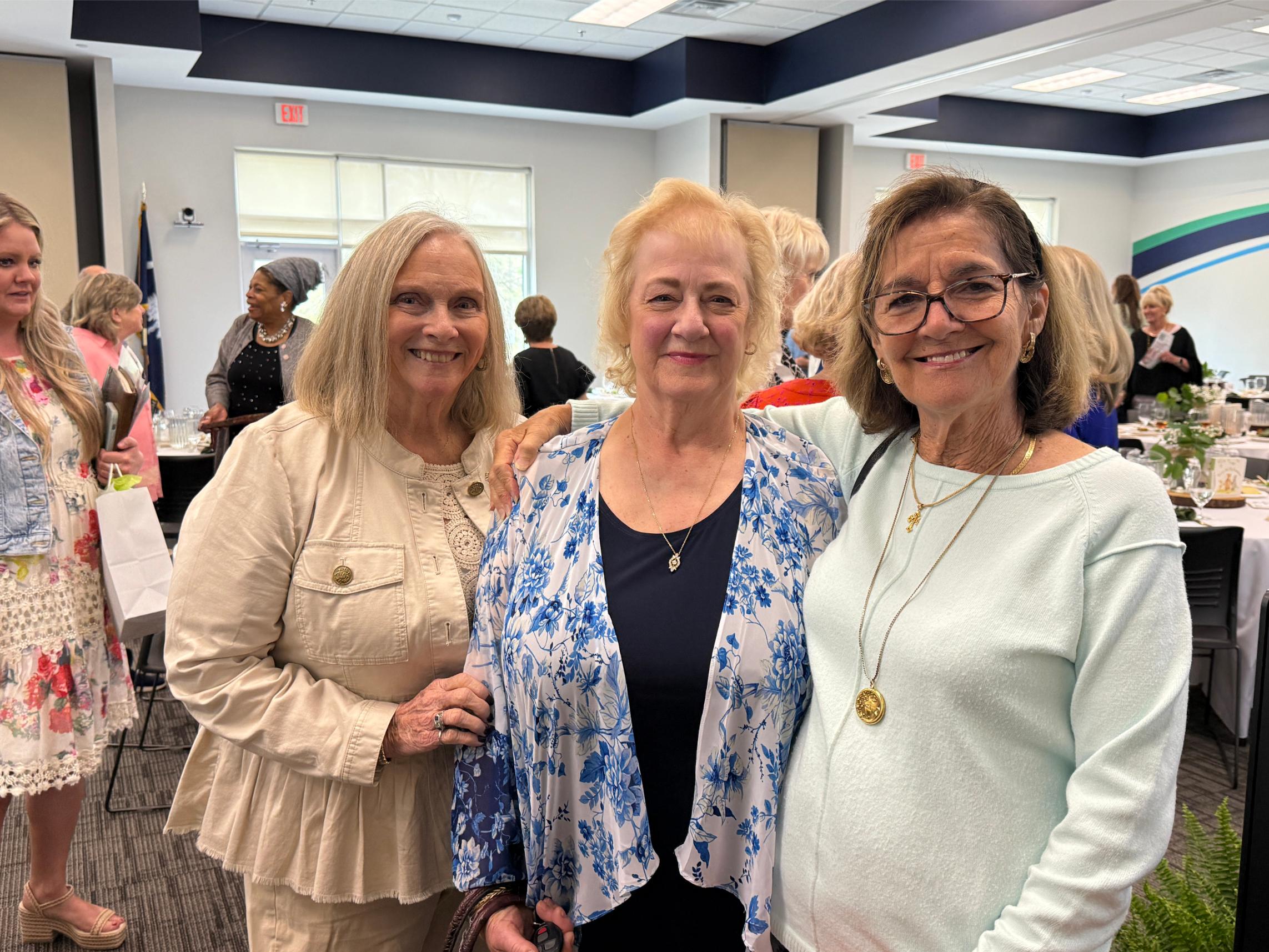 three women posing in luncheon room
