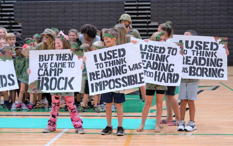 camp irock campers holding signs that say i used to think reading was impossible, but then i came to camp irock