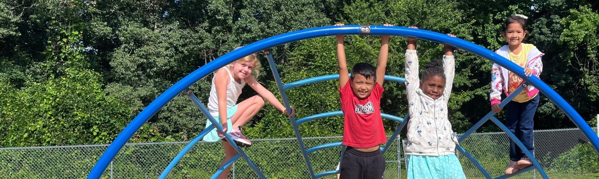 camp irock children hanging on the climber on the playground