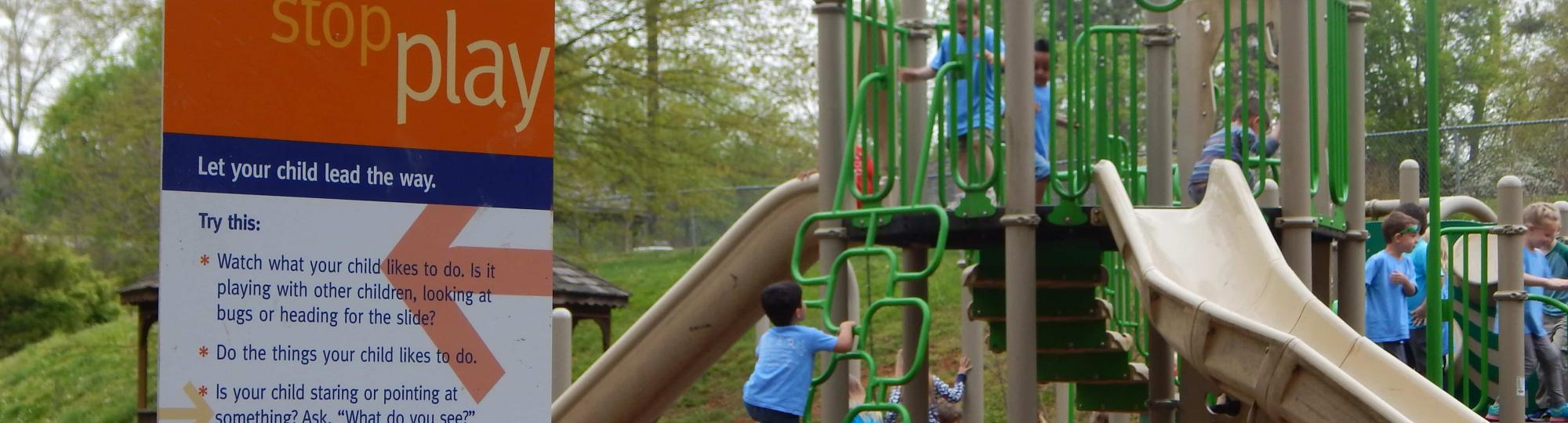 Children on a playground near a born learning trail sign