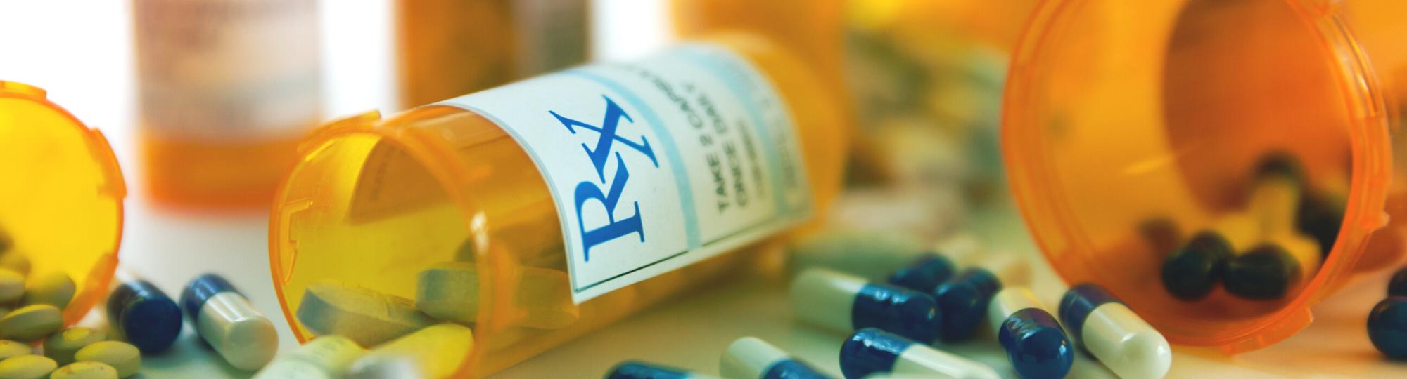 Prescription bottles and pills poured on a table