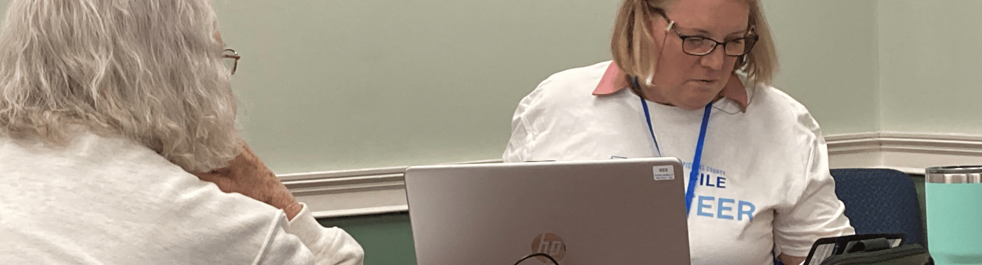 A female Free File volunteer helps another woman with her taxes