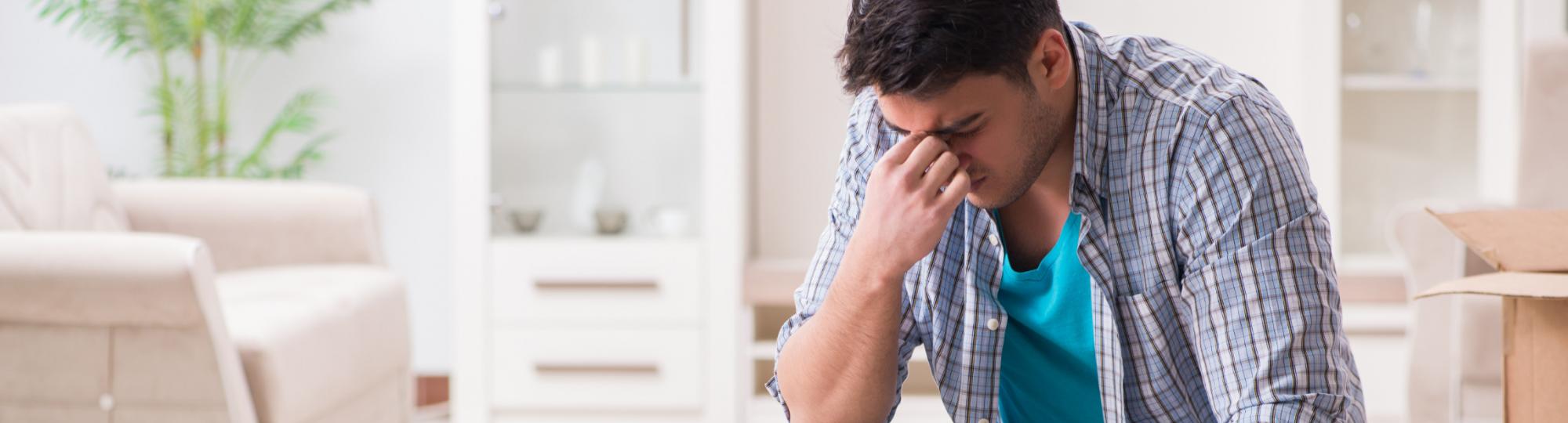 A man sits with his head in his hand