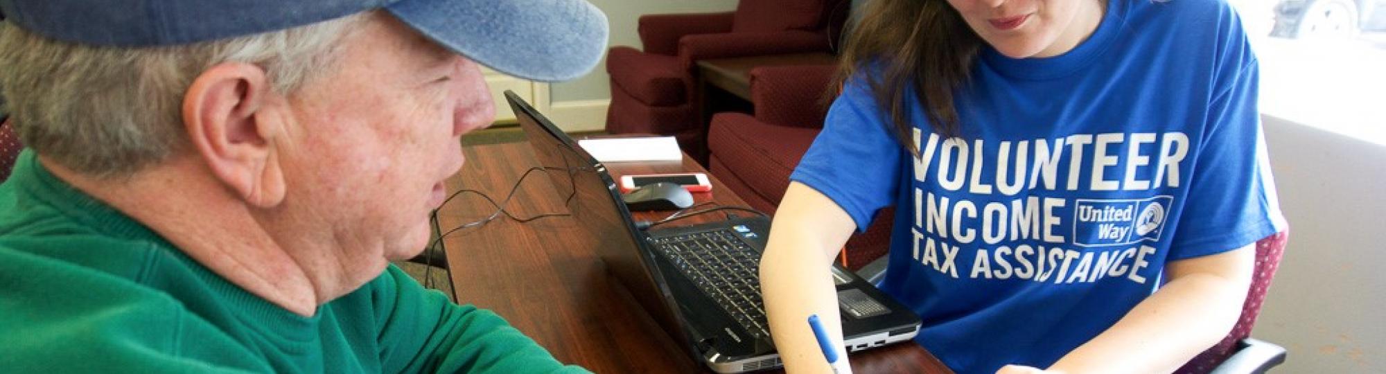 A woman volunteers to help a man with his taxes