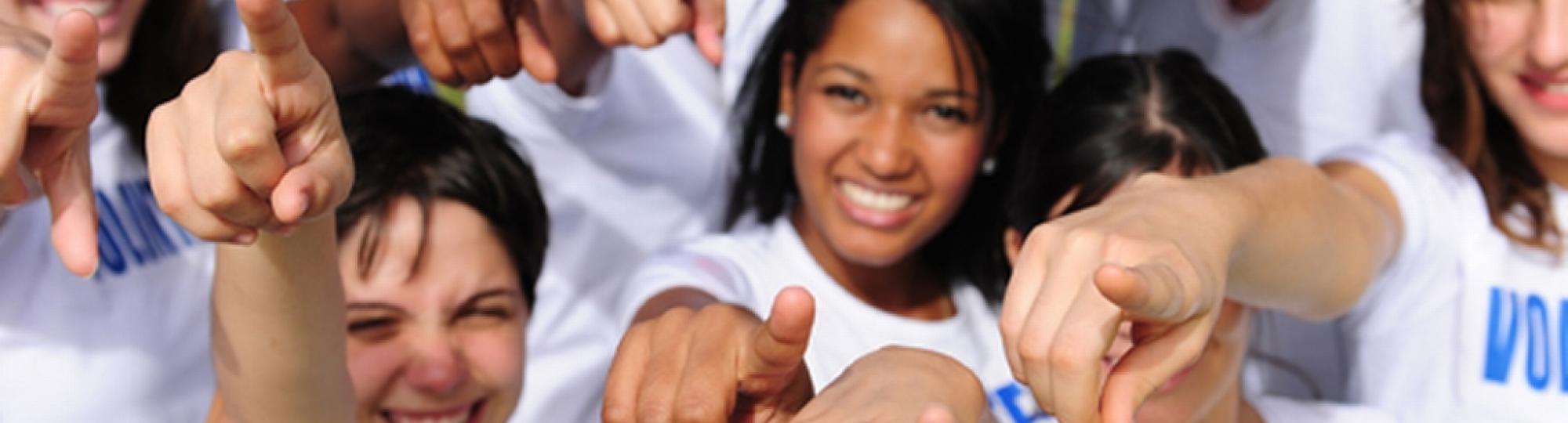 Group of people with VOLUNTEER tshirts pointing at YOU