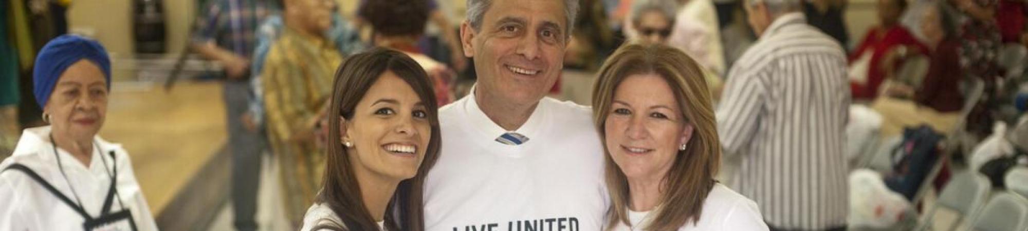 three adults with Live United t-shirts