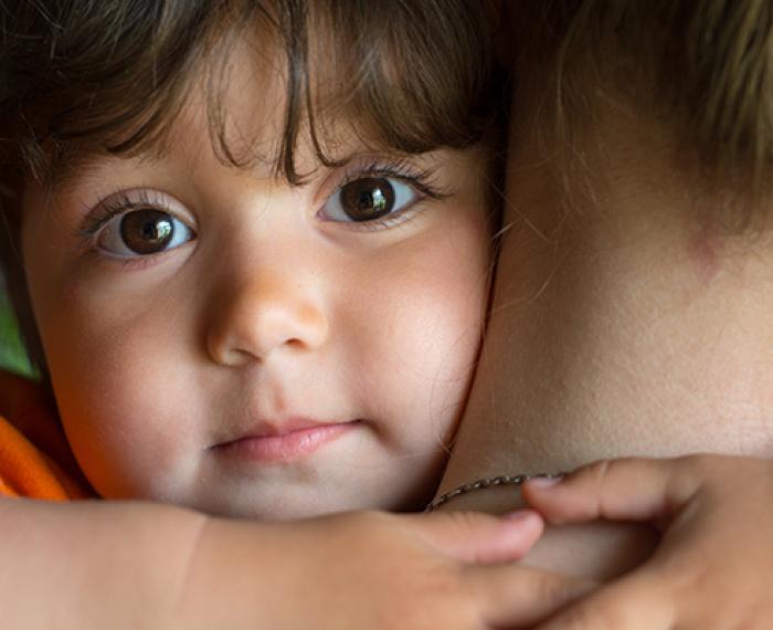 child looking over mothers shoulder