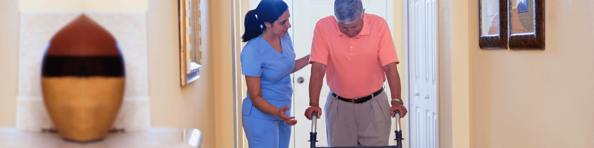 home health worker assisting a man using a walker