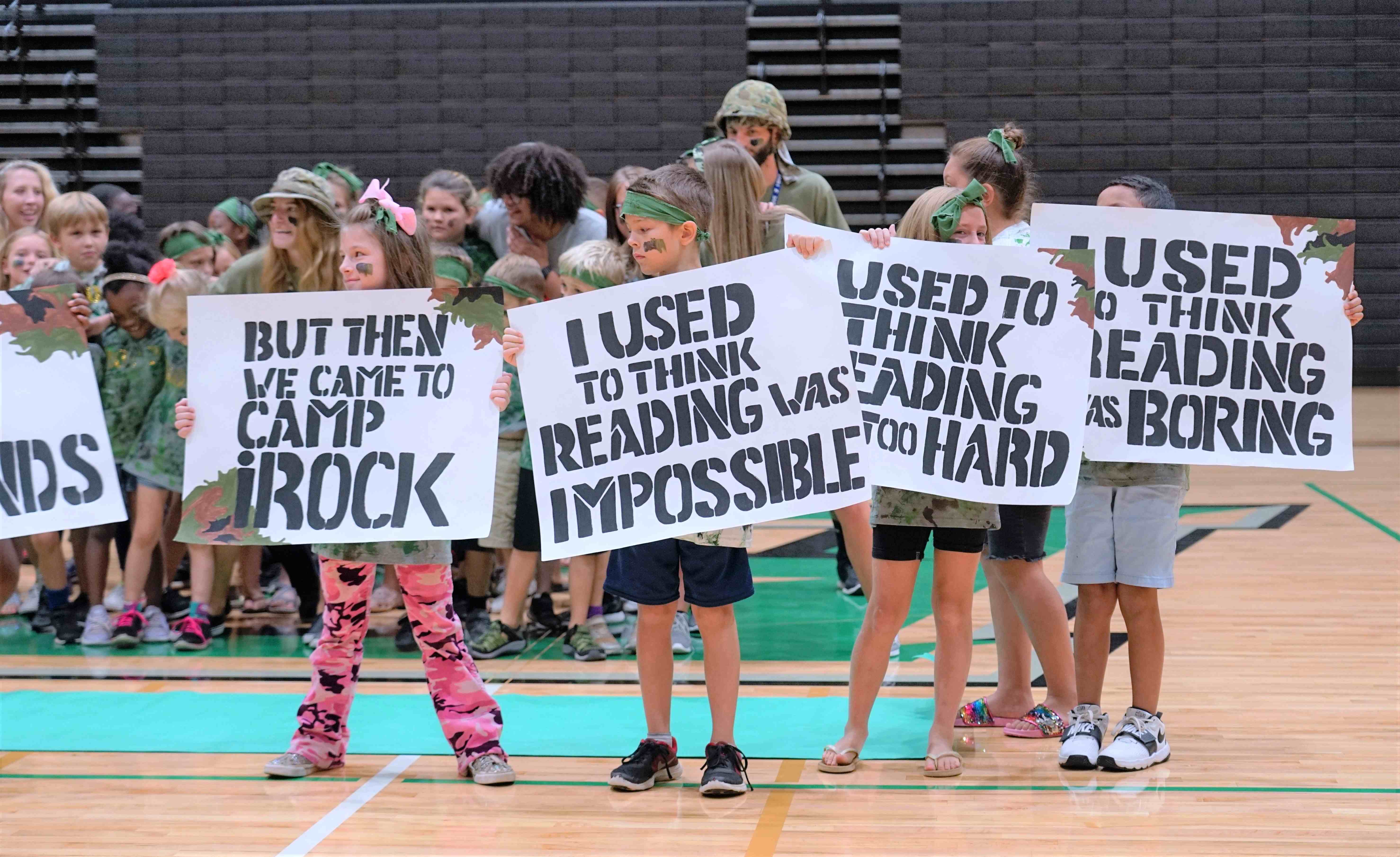 camp irock campers holding signs that say i used to think reading was impossible, but then i came to camp irock