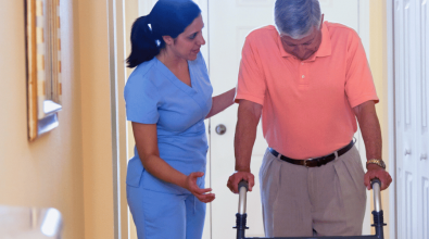 home health worker assisting a man using a walker