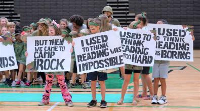 camp irock campers holding signs that say i used to think reading was impossible, but then i came to camp irock