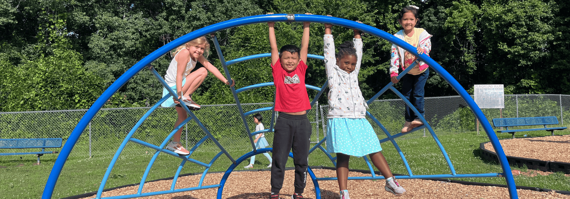 Children in a playground hanging on a play structure