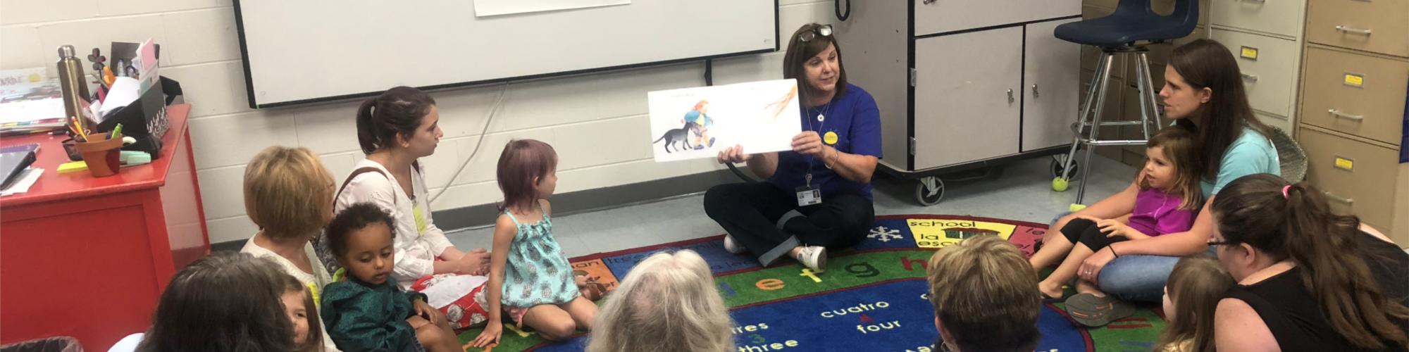 Preschool Pages teacher reading to children and caregivers