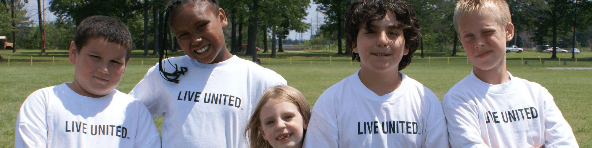 Children outdoors wearing Live United tshirts
