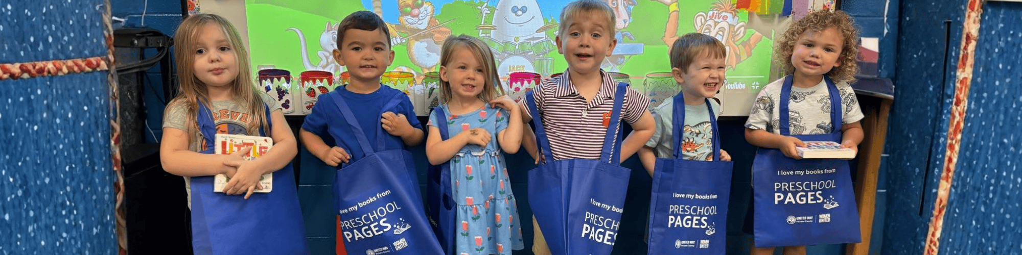 Preschool Pages children holding their book tote bags
