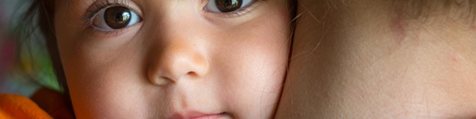 child looking over mothers shoulder