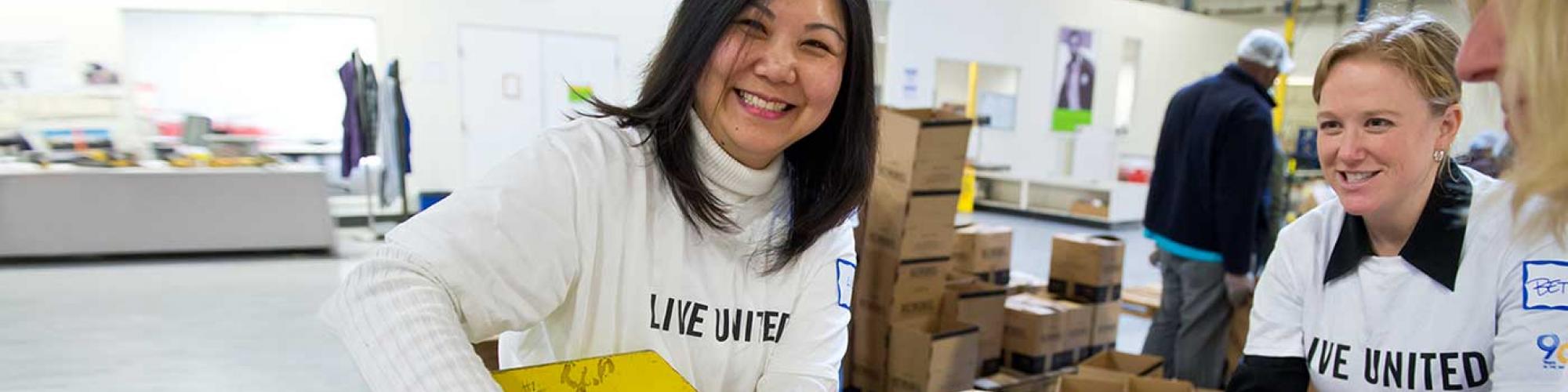 Smiling women packing food in a warehouse