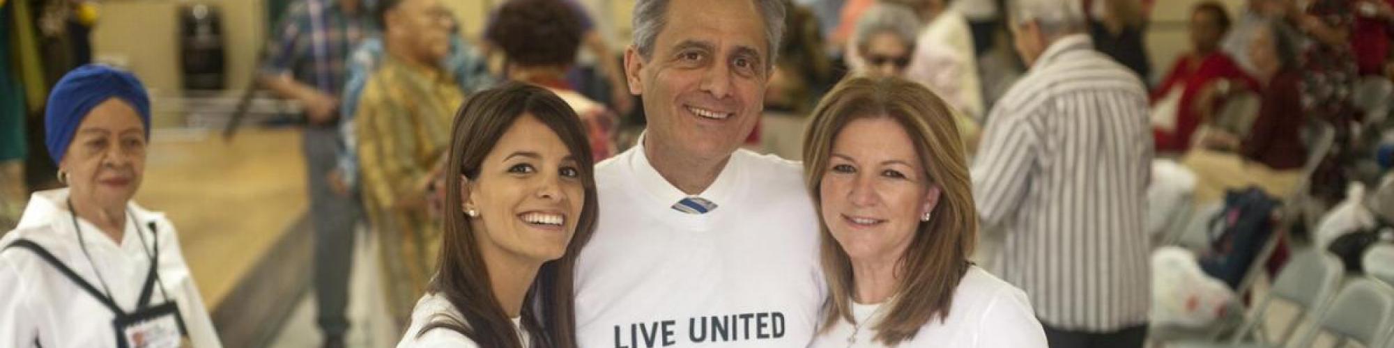 three adults with Live United t-shirts