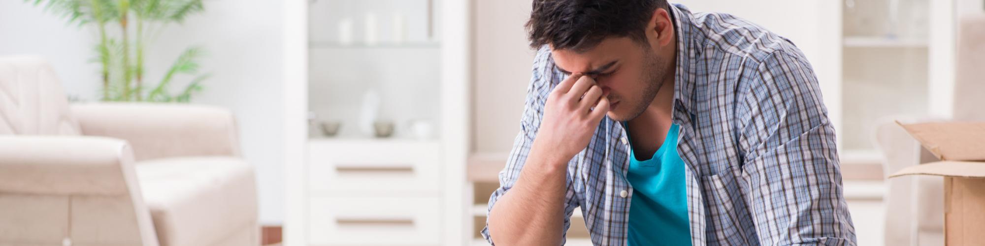 A man sits with his head in his hand